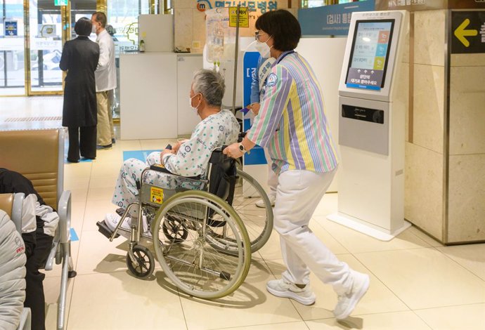 Archivo - March 11, 2024, Seoul, South Korea: Medical staff seen moving a patient in a wheelchair in a hospital in Seoul. South Korea's Ministry of Health and Welfare said on March 11 that it had sent advance notice of license suspension to about 5,000 do