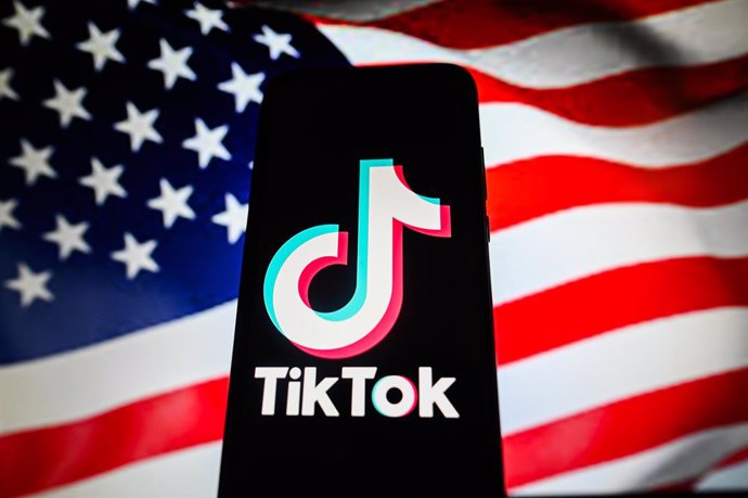 March 23, 2024, Poland: In this photo illustration a TikTok logo is displayed on a smartphone with an USA flag on the background. The U.S. House of Representatives passed a bill looking to remove TikTok from app stores nationwide.