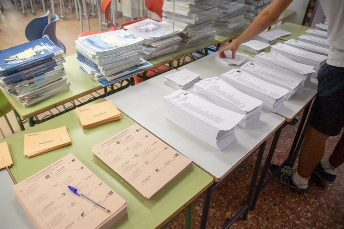 Archivo - Un votante cogiendo papeletas durante las elecciones generales