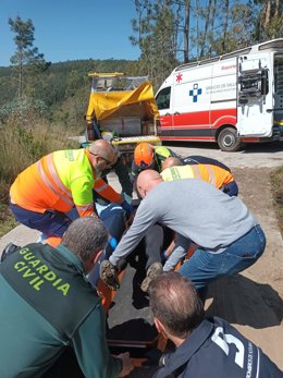 Agentes de la Guardia Civil, bomberos y ambulancia asisten a un ciclista herido en Grado.
