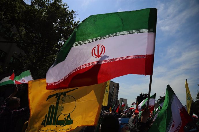 April 19, 2024, Tehran, Iran: Iranians wave flags of Iran and Hezbollah during an anti-Israel rally in Tehran. Air defense systems over the central city of Isfahan destroyed three aerial objects early on April 19. The explosions come after a drone and mis