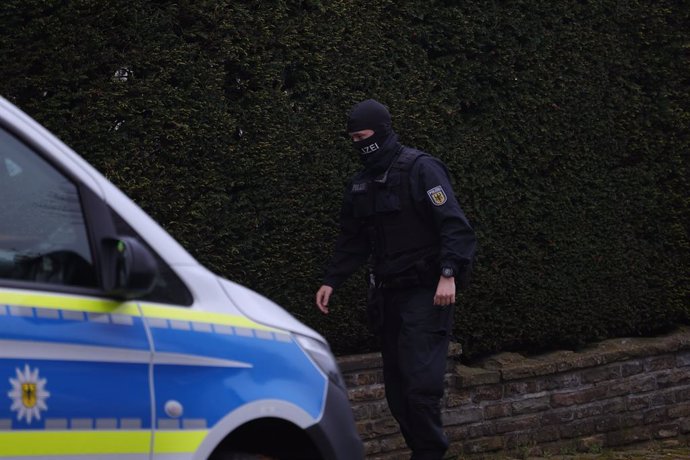 17 April 2024, Solingen: A police officer patrol near a building that is being searched during a large-scale raid against an international smuggling gang in eight states. Photo: Gianni Gattus/dpa