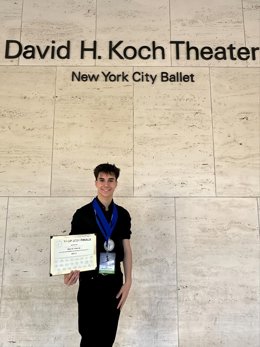 Eloy Gil posa con su diploma en el teatro David H. Koch del Ballet de la Ciudad de Nueva York.