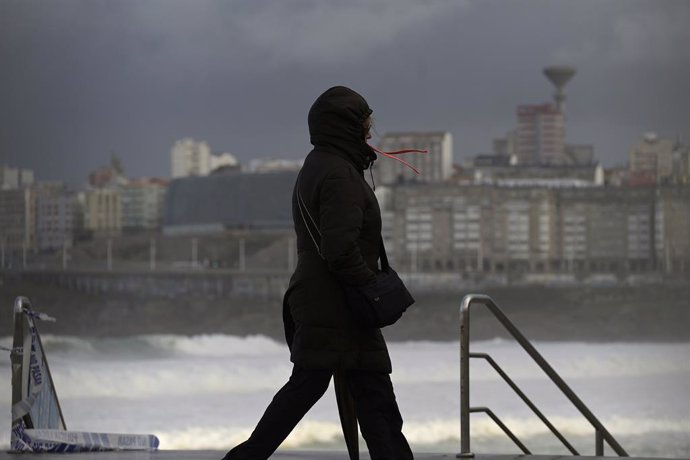 Archivo - Una mujer se cubre con la capucha durante el frente meteorológico, a 23 de febrero de 2024, en A Coruña, Galicia (España). La Agencia Estatal de Meteorología (Aemet) decretó un aviso naranja por temporal costero en el litoral gallego que ya está