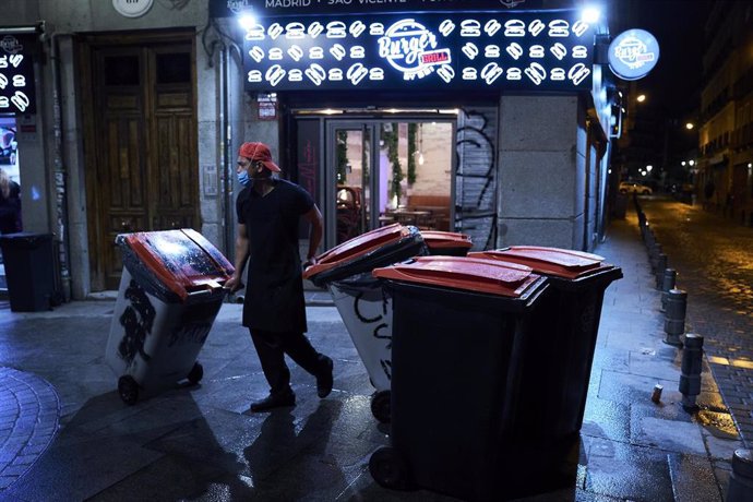 Archivo - Un trabajador recoge los cubos de basura  