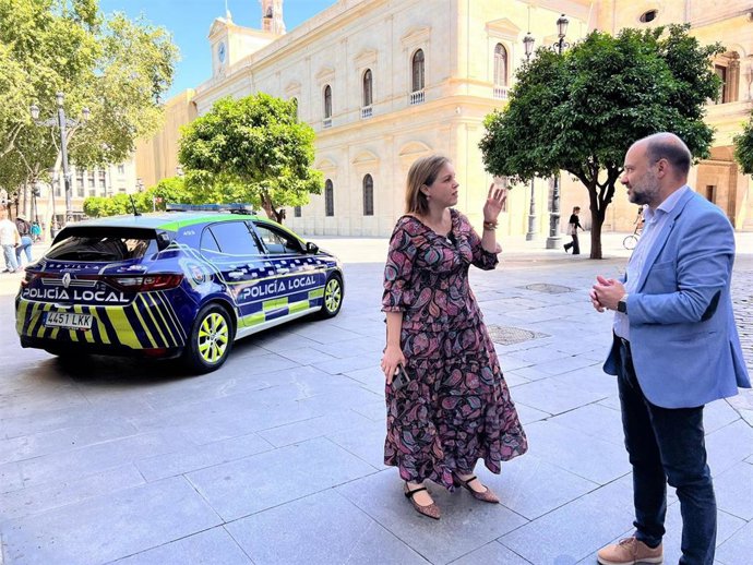 La portavoz de Vox en el Ayuntamiento hispalense, junto a un vehículo de la Policía Local.