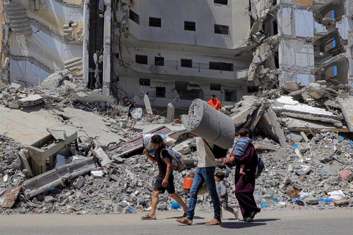 Palestinos junto a un edificio destruido en la ciudad de Rafá, en el sur de la Franja de Gaza