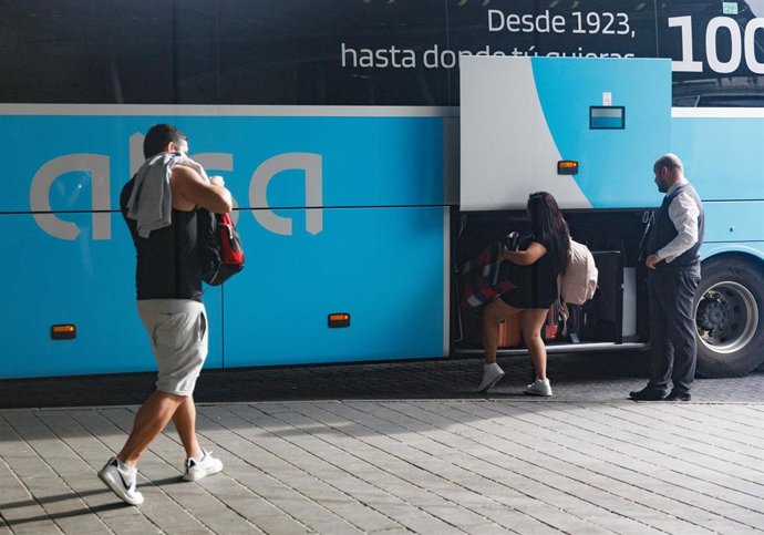 Archivo - Viajeros depositando sus maletas en el maletero de un autobús 