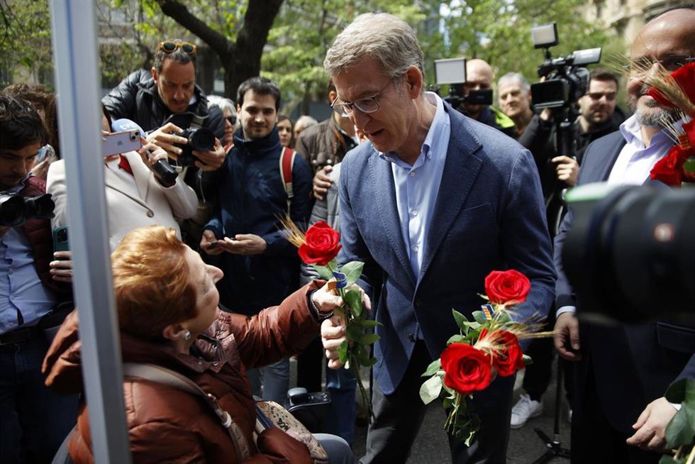 Una mujer ofrece una rosa al presidente del PP, Alberto Núñez Feijóo, durante su visita a Barcelona por el día de Sant Jordi, a 23 de abril de 2024, en Barcelona, Catalunya (España). Feijóo ha aprovechado la ocasión para apoyar al presidente del PP de C