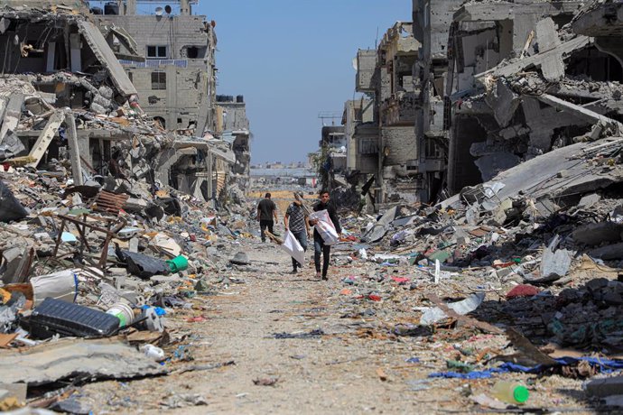 Palestinos caminan entre edificios destruidos por los bombardeos del Ejército de Israel contra la ciudad de Jan Yunis, en el sur de la Franja de Gaza (archivo)