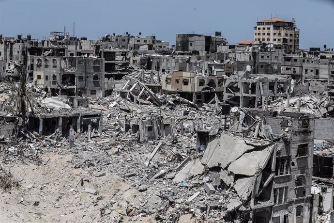 April 21, 2024, Khan Yunis, Gaza Strip, Palestinian Territory: People walk past destroyed buildings in Khan Yunis in the southern Gaza Strip on April 21, 2024 (Issued 23 April 2024). amid the ongoing Israel war on Gaza. Israel pulled its ground forces fro