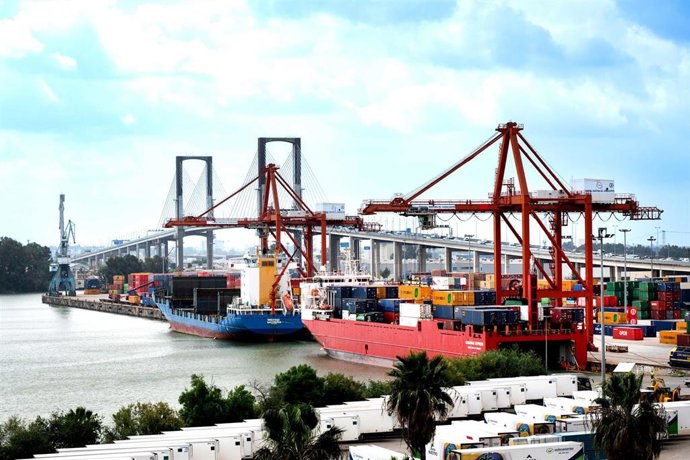 Imagen de recurso de buques con contenedores en el Puerto de Sevilla, con el Puente del Centenario al fondo.