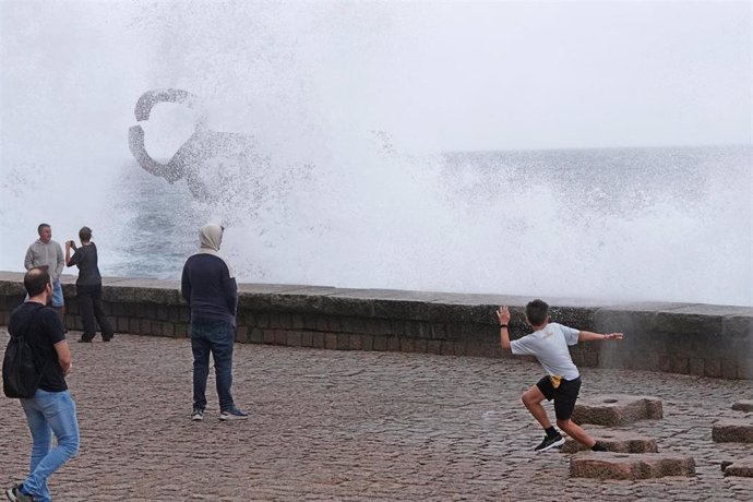 Archivo - Varias personas se mojan con las olas en el Peine del Viento,