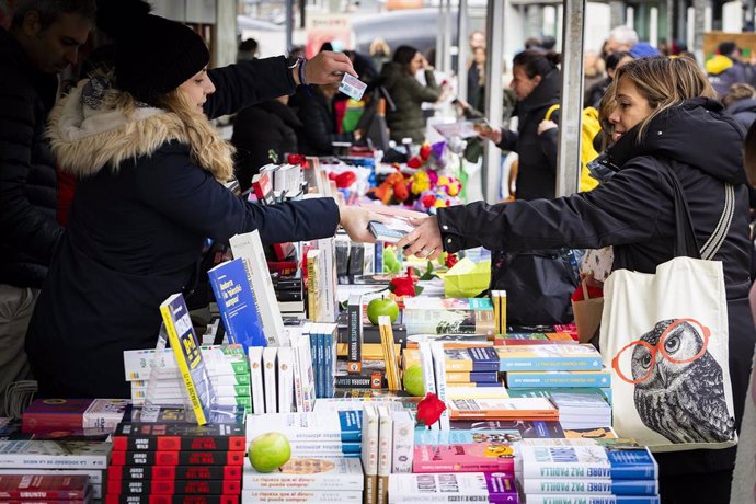 Una mujer compra libros en la feria de la Diada de Sant Jordi en Andorra la Vella, a martes 23 de abril de 2024