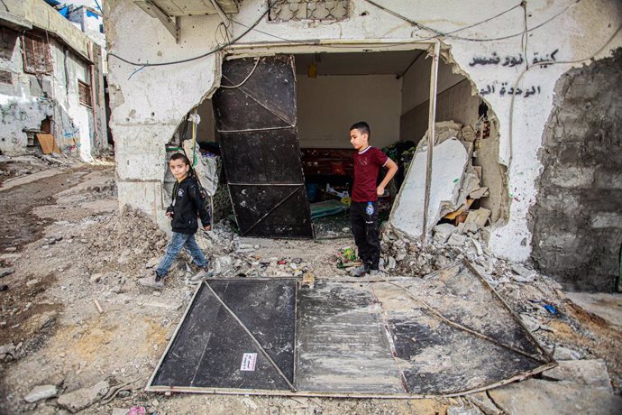 April 22, 2024, Tulkarm, West Bank, Palestine: Palestinians walk between rubble following a deadly raid by Israeli forces that began Thursday night in the Nur Shams refugee camp near the West Bank town of Tulkarem.