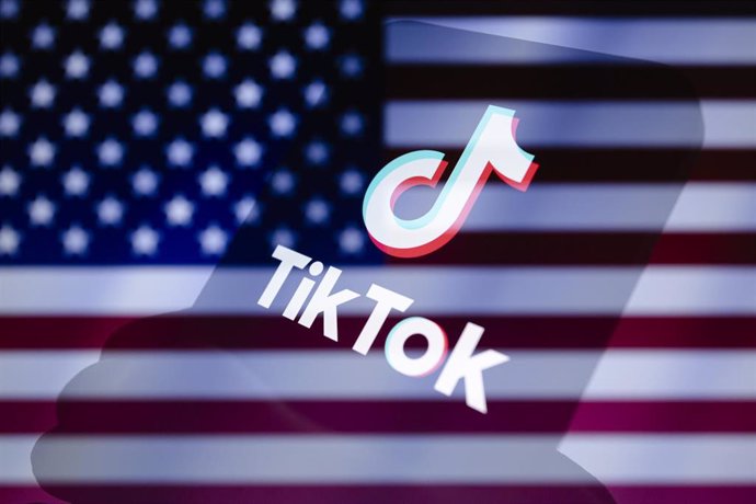 Archivo - Logo de TikTok sobre una bandera de EEUU