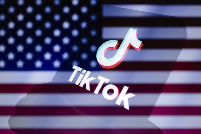 Archivo - March 14, 2024, Asuncion, Paraguay: TikTok logo is displayed on a smartphone backdropped by cropped flag of the United States.
