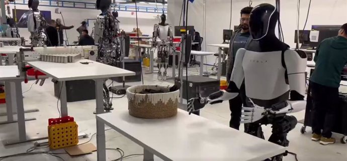El robot humanoide Optimus Gen 2 doblando una camiseta.