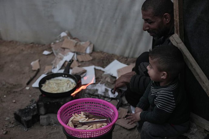 Archivo - Desplazados palestinos preparan comida en un campo de refugiados de Gaza.