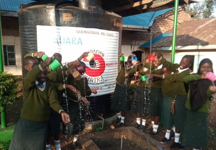 Alumnos de la escuela de Primaria de Nyamaranya en Kuria (Kenia) con el tanque de 10.000 litros que ha construido AUARA gracias a la venta de 150.000 botellas de la compañía por parte de la productora de teatro musical Stage Entertainment.