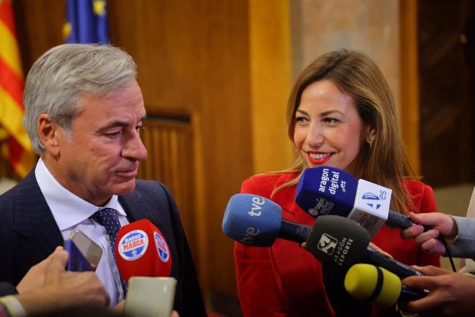 El piloto Carlos Sainz y la alcaldesa de Zaragoza, Natalia Chueca, en el Arco de Banderas del Ayuntamiento zaragozano