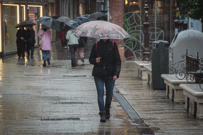 Archivo - Varias personas se protegen de la lluvia bajo sus paraguas. A 9 de febrero de 2024, en Sevilla (Andalucía, España). La borrasca 'Karlotta' activa avisos por lluvia, viento y oleaje en todas las provincias andaluzas.