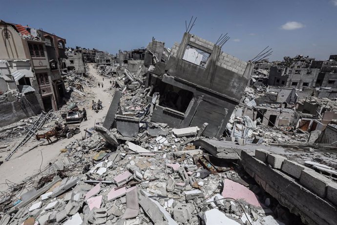 April 21, 2024, Khan Yunis, Gaza Strip, Palestinian Territory: People walk past destroyed buildings in Khan Yunis in the southern Gaza Strip on April 21, 2024 (Issued 23 April 2024). amid the ongoing Israel war on Gaza. Israel pulled its ground forces fro