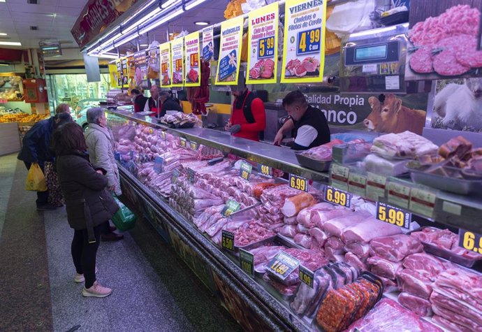 Archivo - Varias personas compran en una carnicería  en un mercado, a 15 de marzo de 2023