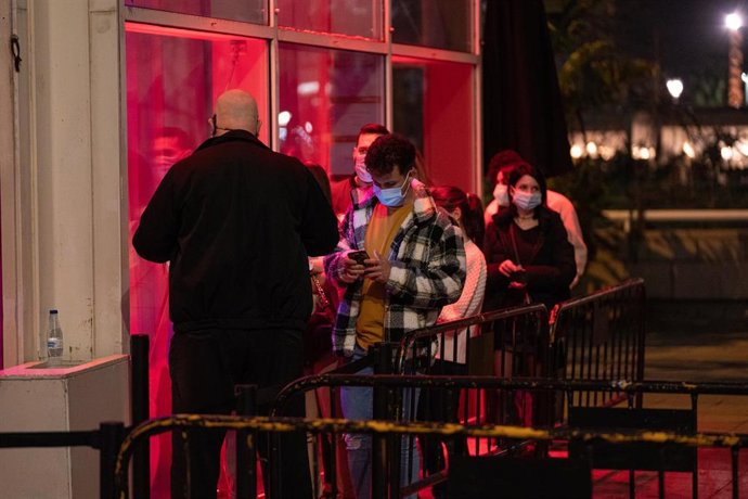 Archivo - Un grupo de personas esperan a entrar a una discoteca en Barcelona.