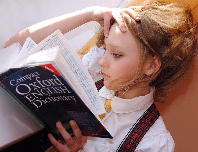 Persona leyendo con un diccionario Oxford de inglés