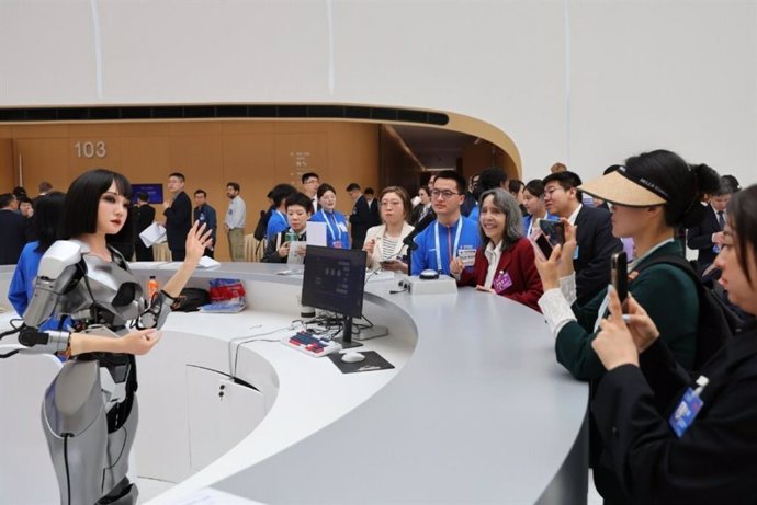 Visitors interact with a humanoid robot at the opening of the 2024 Zhongguancun Forum in Beijing on Thursday.