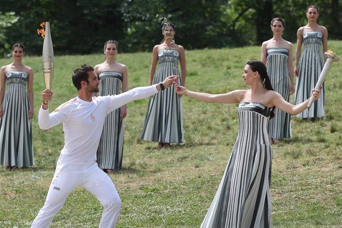 ANCIENT OLYMPIA, April 16, 2024  -- Greek actress Mary Mina (front R), in the role of the High Priestess, hands an olive branch to the first torch bearer, Greek rowing Olympic champion Stefanos Ntouskos (front L), during the Olympic flame lighting ceremon