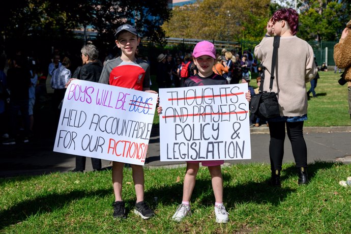 27 April 2024, Australia, Sydney: Two girls hold placards during a rally to a call for action to end violence against women. Photo: Steven Markham/AAP/dpa