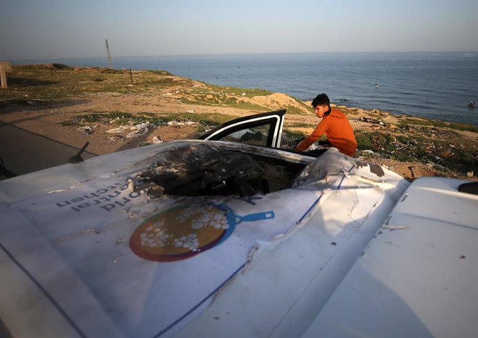DEIR EL-BALAH, April 2, 2024  -- A Palestinian checks a damaged vehicle after Israeli strikes in central Gaza Strip city of Deir el-Balah, on April 2, 2024. Israel on Tuesday assumed responsibility for the killing of seven workers of international food ch