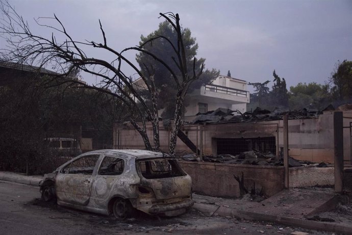 Archivo - Vehículos y vivendas destruidos por un incendio en la región griega de Ática en el verano de 2018
