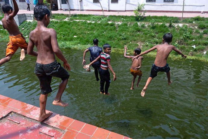 April 29, 2024, Narayanganj, Dhaka, Bangladesh: Children play with water in a river in Narayanganj, Bangladesh to relieve themselves from the heat wave that Sweeps over the country. Bangladesh experienced its longest heat wave in recorded history this Apr
