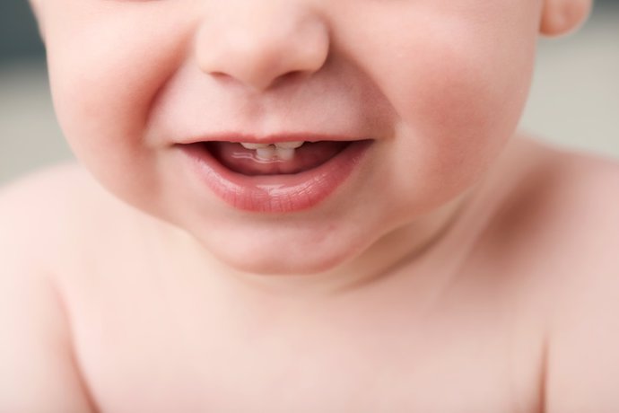 Archivo - Tight crop of baby's mouth showing his first teeth bebé mostrando sus primeros dientes