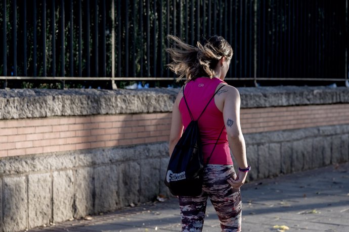 Archivo - Chica pasea por la calle, a 17 de octubre de 2023, en Madrid (España). La Agencia Estatal de Meteorología (Aemet) ha activado la alerta naranja por fuertes rachas de viento, lo que ha obligado al Ayuntamiento de Madrid a balizar los parques de E