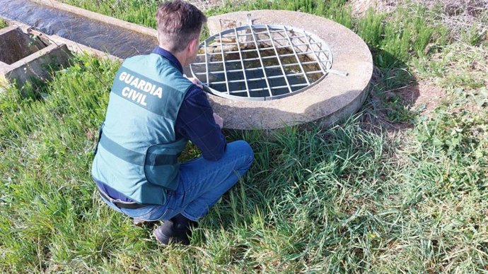Un agente del Equipo Roca de la Guardia Civil ante una de las rejillas de seguridad..