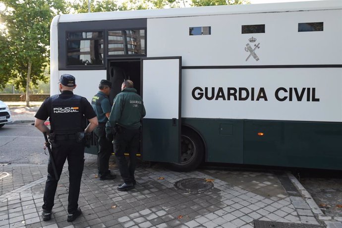 Archivo - Varios agentes de la Guardia Civil y de Policía Nacional junto a un autobús de la Guardia Civil.
