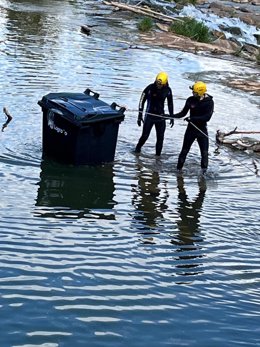Bomberos sacando el contenedor del Ebro este fin de semana