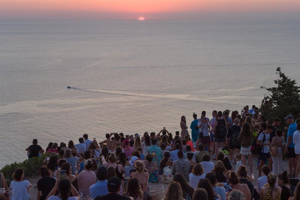 Archivo - Grupos de personas disfrutan del atardecer en la Cala d'Hort, a 7 de agosto de 2022, en Ibiza, Baleares (España). La Cala d'Hort  es una playa desde la que se puede disfrutar de las vistas sobre el misterioso islote de Es Vedr, que se levanta