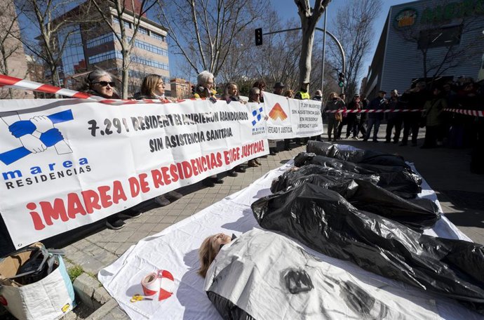 Archivo - Varias personas participan durante una performance, de Marea de Residencias y Verdad y Justicia, para protestar por los fallecimientos de mayores durante la pandemia, en las puertas de la Asamblea de Madrid, a 2 de marzo de 2023, en Madrid (