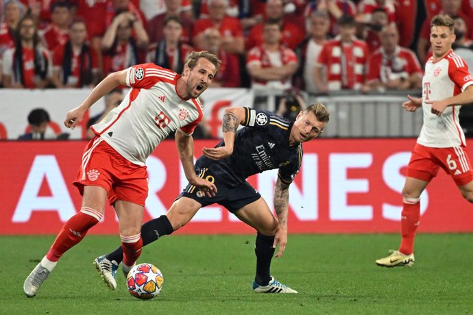 30 April 2024, Bavaria, Munich: Bayern Munich's Harry Kane (L) and Real Madrid's Toni Kroos battle for the ball during the UEFA Champions League semi-final first leg soccer match between Bayern Munich and Real Madrid at Allianz Arena. Photo: Sven Hoppe/dp