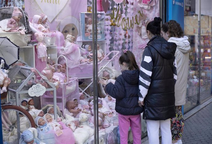 Archivo - Varias personas miran el escaparate de una tienda de juguetes. A 27 de diciembre de 2022, en Sevilla (Andalucía, España).