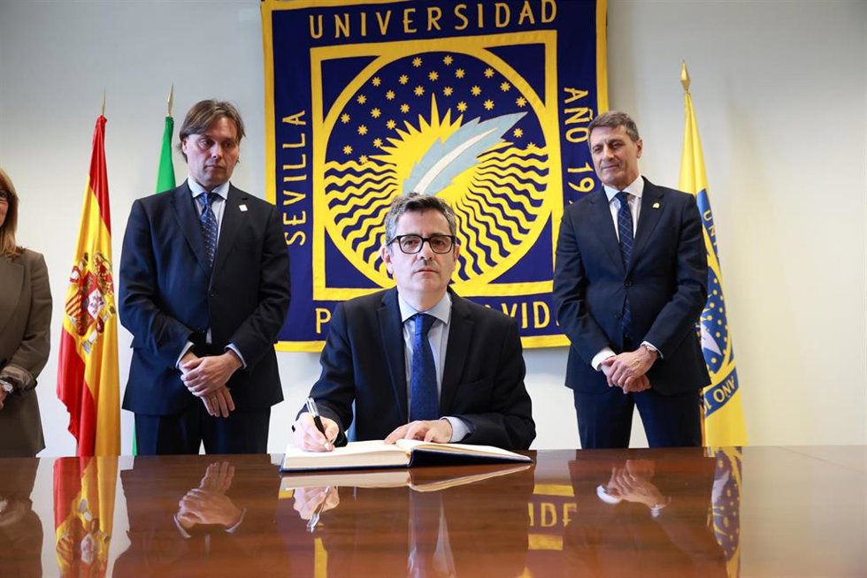 El ministro de la Presidencia, Justicia y Relaciones con las Cortes, Félix Bolaños (c), junto al rector de la UPO, Francisco Oliva (i), y el delegado del Gobierno en Andalucía, Pedro Fernández (d), firma en el Libro de Honor de la UPO.