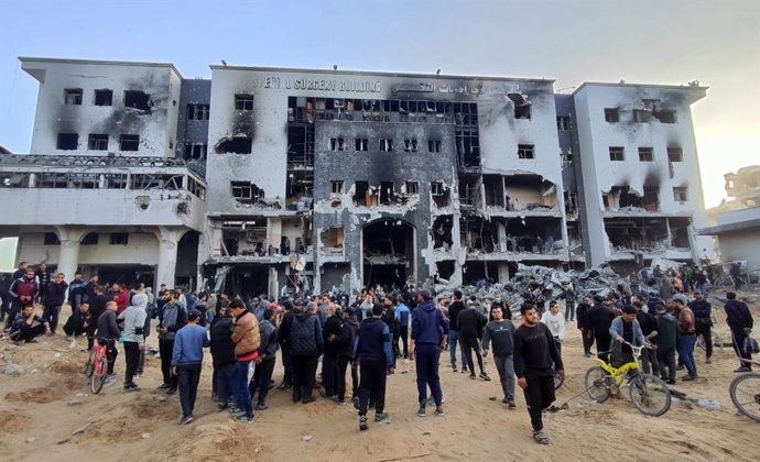 Archivo - Personas frente a la fachada destruida del Hospital Al Shifa de Ciudad de Gaza