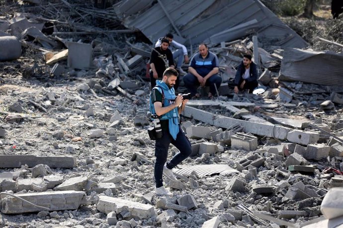 Archivo - Un periodista cubre la destrucción de casas palestinas causados por los bombardeos israelíes en el centro de la Franja de Gaza