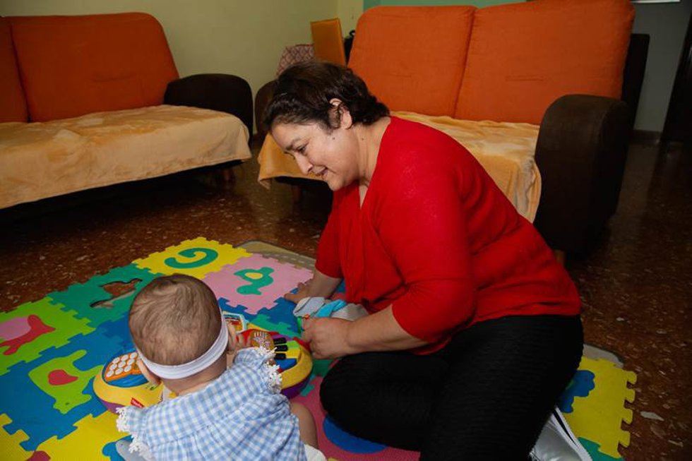 Mujer con uno de sus hijos en su vivienda de alquiler