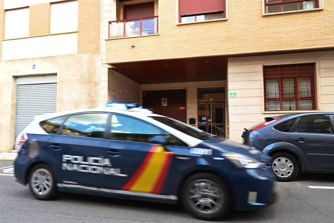 Un coche de la Policía Nacional en el portal donde presuntamente un menor de 17 años ha matado a su madre tras una discusión